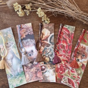 Photo de marque-pages Rosana Illustration, thème Automne, cinq modèles avec animaux des bois dans des couleurs chaudes, aquarelles réalistes, les marque-pages sont agrémentés de pompons assortis